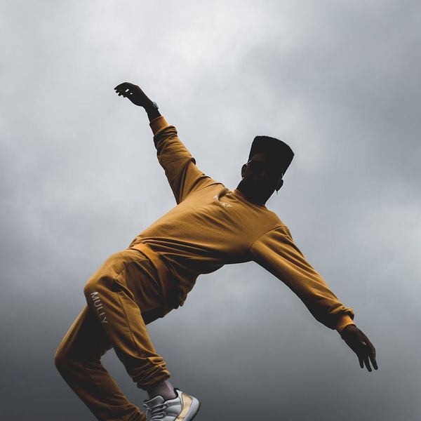 Silhouette of a man in a powerful pose against a sunrise, symbolizing energy and balance.
